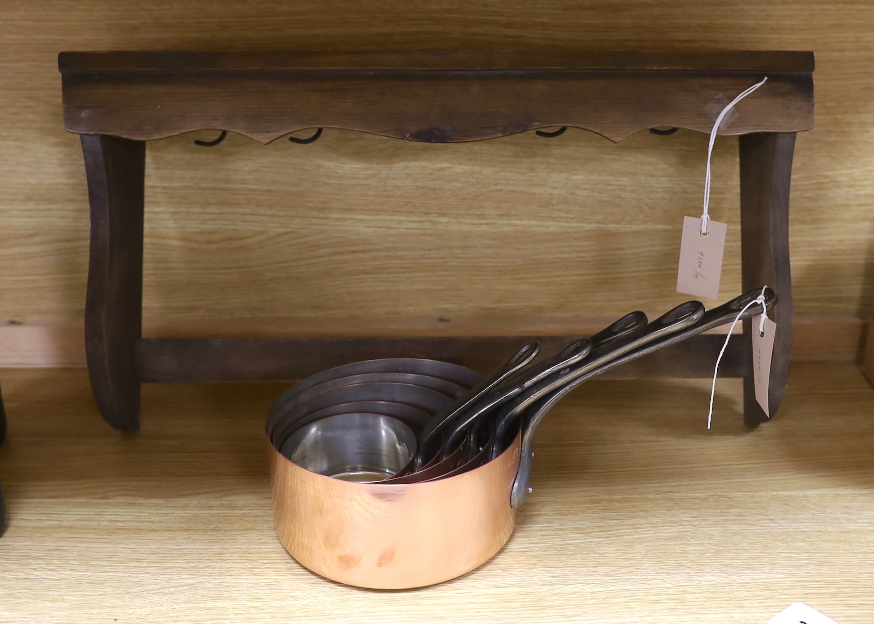 A set of five French copper saucepans, and a pendant from pine rack